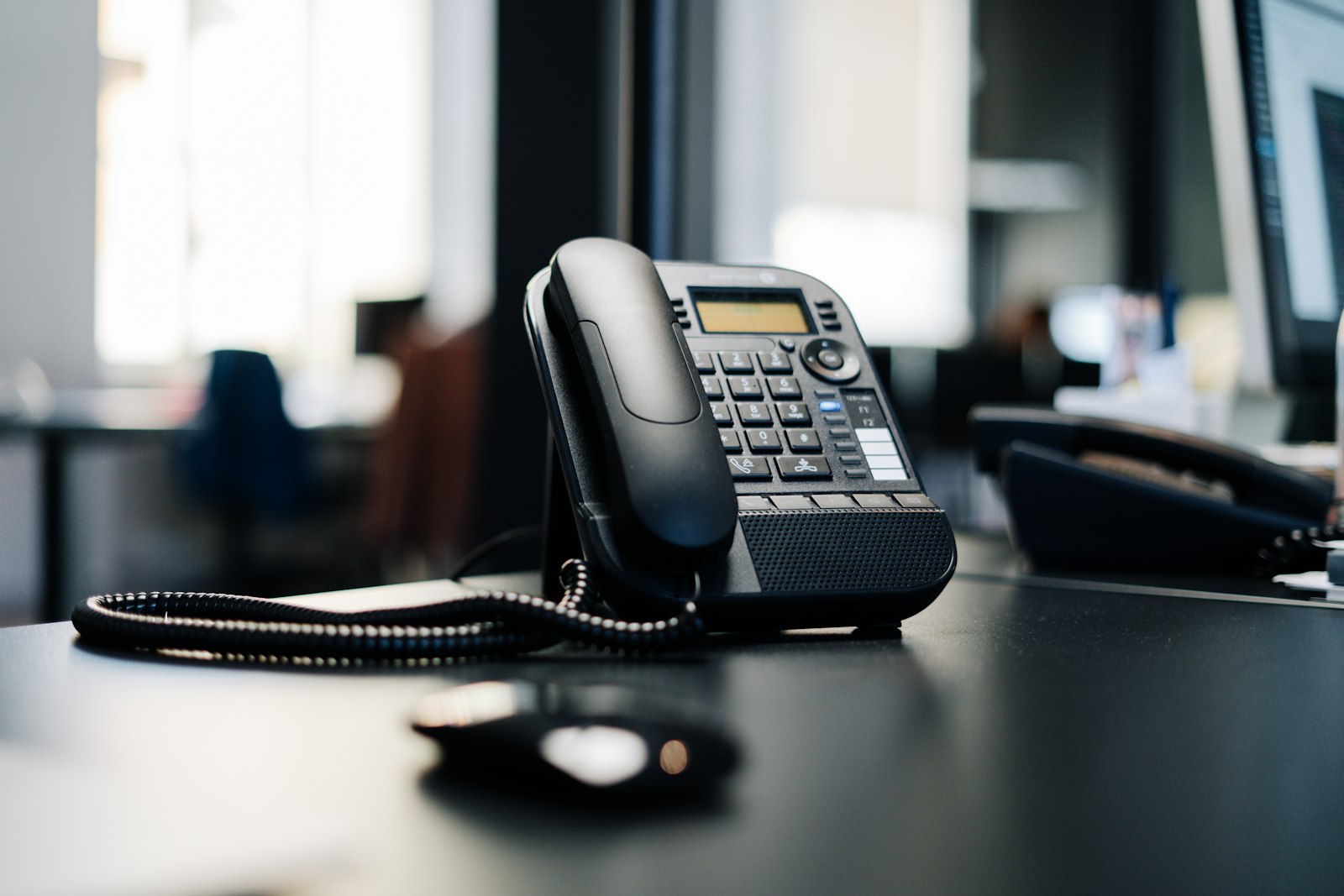Ofis masasında kulaklıklı telefon ve dizüstü bilgisayar, çağrı kaydı ortamını çağrıştırıyor
